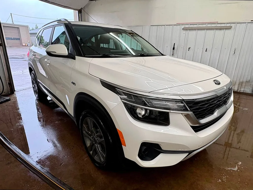 White Kia SUV wet in the CarShine wash bay
